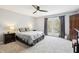 Primary bedroom featuring neutral decor, plush carpeting, patio access, and a ceiling fan at 9132 Log Run N Dr, Indianapolis, IN 46234
