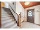 Inviting foyer with staircase, wood accents, and tile flooring leading to the main living areas at 9132 Log Run N Dr, Indianapolis, IN 46234