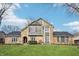 Charming two-story stone and wood home with a well-maintained lawn under a blue sky at 9132 Log Run N Dr, Indianapolis, IN 46234