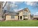 Charming two-story stone and wood home with a well-maintained lawn under a blue sky at 9132 Log Run N Dr, Indianapolis, IN 46234