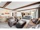 Open-concept living room with stone bar, exposed beams, and seamless flow to the kitchen at 9132 Log Run N Dr, Indianapolis, IN 46234
