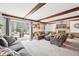 Cozy living room with exposed beams, stone fireplace, and sliding glass doors to the backyard at 9132 Log Run N Dr, Indianapolis, IN 46234