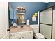 Bathroom features a tile shower, framed mirror, and white vanity at 9640 Clover Leaf Ln, Fishers, IN 46038