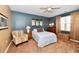 Comfortable bedroom featuring blue accent wall, ceiling fan, and neutral decor at 9640 Clover Leaf Ln, Fishers, IN 46038