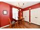 Bright kitchen with red accent wall, hardwood floors, and modern light fixture at 9640 Clover Leaf Ln, Fishers, IN 46038