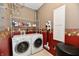 Functional laundry room with washer, dryer, storage shelves, and a patterned accent wall at 9640 Clover Leaf Ln, Fishers, IN 46038