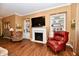 Living room with fireplace, built in shelving, laminate flooring, and warm natural lighting at 9640 Clover Leaf Ln, Fishers, IN 46038