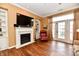 Bright living room with white fireplace, built in shelving, and wood laminate flooring at 9640 Clover Leaf Ln, Fishers, IN 46038