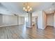 A spacious living room with wood floors, ceiling fan, and light fixtures, plus kitchen access at 110 E Washington St # 1102, Indianapolis, IN 46204