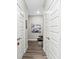 Hallway with laminate floors and multiple paneled doors and storage, bright neutral paint at 11758 Harvester S Cir, Noblesville, IN 46060