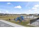 Blue playground with slides and swings next to a pond with a water fountain at 11758 Harvester S Cir, Noblesville, IN 46060