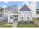 Charming home with a gabled roof, covered porch, tidy landscaping, and freshly painted gray siding at 1210 S State Ave, Indianapolis, IN 46203
