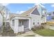 Charming gray home with a cozy covered porch, gabled roof, well-kept lawn, and freshly painted siding at 1210 S State Ave, Indianapolis, IN 46203