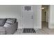 Bright interior featuring wood-look flooring, a decorative front door, and a comfortable gray sofa at 1210 S State Ave, Indianapolis, IN 46203