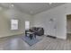 Cozy living room featuring wood-look flooring, a gray sofa, and a decorative front door with natural light at 1210 S State Ave, Indianapolis, IN 46203
