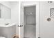 Modern bathroom with tiled shower and gray vanity and view into the bedroom at 1254 Mcdougal St, Indianapolis, IN 46203