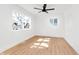 Bright bedroom with light wood floors, a ceiling fan, and ample natural light from two windows at 1254 Mcdougal St, Indianapolis, IN 46203
