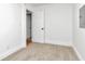 A simple bedroom with neutral carpet, white walls, and a white door at 1254 Mcdougal St, Indianapolis, IN 46203