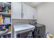 This laundry room includes a washer and dryer, along with shelving and white cabinets for ample storage at 12777 Rotterdam Rd, Fishers, IN 46037