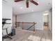 Upstairs loft area with ceiling fan, wood flooring, and spindled railing overlooking the lower level of the home at 12777 Rotterdam Rd, Fishers, IN 46037