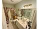 This bathroom features a shower with curtain, vanity, toilet, and linen storage cabinet at 1408 Lawrence Way, Anderson, IN 46013