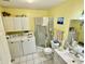 Bathroom featuring a glass shower, white cabinets, single sink vanity, and stacked washer/dryer at 1408 Lawrence Way, Anderson, IN 46013