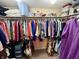 A walk-in closet features extensive rod and shelf storage, with many clothing items at 1408 Lawrence Way, Anderson, IN 46013