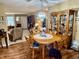 Open dining area with wood floors, ceiling fan, and clear view of the living room and entryway at 1408 Lawrence Way, Anderson, IN 46013