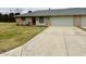 View of charming brick home, driveway, and manicured front lawn, with attached garage at 1408 Lawrence Way, Anderson, IN 46013