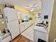 This galley kitchen offers white cabinetry, matching white appliances and tile flooring at 1408 Lawrence Way, Anderson, IN 46013