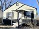 Charming home with light yellow siding and black trim, featuring a covered front porch at 1422 E 49Th St, Indianapolis, IN 46205