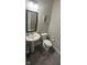 Cozy powder room featuring a pedestal sink, black-framed mirror, neutral walls, and stylish decor at 15408 Brown Jack Dr, Fishers, IN 46040