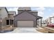 Front exterior of a house showing the attached garage with gray doors and brown siding at 1668 Carrollton Rail Dr, Westfield, IN 46074