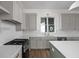 An open kitchen featuring stainless appliances, wood flooring, and gray cabinets with white countertops at 1668 Carrollton Rail Dr, Westfield, IN 46074