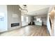 Spacious living room featuring modern fireplace, decorative wall, hardwood floors, and view of the kitchen at 1668 Carrollton Rail Dr, Westfield, IN 46074