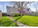 View of the backyard and back of a blue home with a yellow door and lush green lawn at 1724 Prospect St, Indianapolis, IN 46203