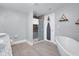 A bright bathroom features a standalone tub, a glass shower, and a double vanity with granite countertop at 1724 Prospect St, Indianapolis, IN 46203