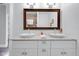 Bathroom featuring dual sinks, a granite countertop, a large mirror, and a white cabinets at 1724 Prospect St, Indianapolis, IN 46203