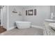 A modern bathroom features a standalone tub, a double vanity with granite countertops, and artwork at 1724 Prospect St, Indianapolis, IN 46203