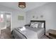 Relaxing bedroom featuring a bed with gray bedding, a nightstand, and decorative wall art at 1724 Prospect St, Indianapolis, IN 46203