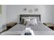 Close-up of a neatly made bed with soft gray bedding and decorative pillows at 1724 Prospect St, Indianapolis, IN 46203