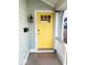 Close-up of a cheerful yellow front door, complete with modern hardware and a security camera at 1724 Prospect St, Indianapolis, IN 46203