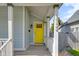 Close-up of the front porch featuring a bright yellow door, white railing, and the house number at 1724 Prospect St, Indianapolis, IN 46203