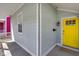 Angled view of the front porch highlighting the yellow door, gray siding, and mailbox at 1724 Prospect St, Indianapolis, IN 46203