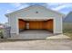 Open garage featuring a concrete floor, wood framing, and a door to the backyard at 1724 Prospect St, Indianapolis, IN 46203