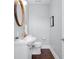 Well-lit powder room featuring wood floors, vanity with a round mirror, and toilet at 1724 Prospect St, Indianapolis, IN 46203