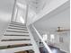 Elegant staircase with white and brown steps leading to a bright and airy living area with modern decor at 1724 Prospect St, Indianapolis, IN 46203