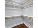 A walk-in closet features white shelving and wooden rods for ample storage space at 1724 Prospect St, Indianapolis, IN 46203