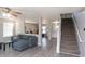 Cozy living room featuring modern floors, a comfortable couch, and an open stairway at 1841 Sonesta Ln, Indianapolis, IN 46217
