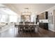Open-concept dining room features dark wood floors and a modern chandelier that complements the kitchen at 19149 Gillcrest Dr, Noblesville, IN 46062